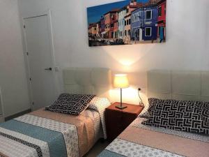 a bedroom with two beds and a lamp on a table at AME137 in Les tres Cales +44 photos