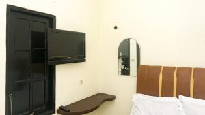 a bedroom with a tv on the wall and a bed at RedDoorz near Sentani Airport Jayapura in Jayapura