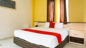 a bedroom with a large white bed with a window at RedDoorz near Pelabuhan Jayapura in Jayapura