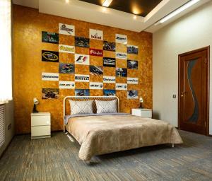 1 dormitorio con 1 cama y una pared de pegatinas en Forum Hotel, en Tyumen