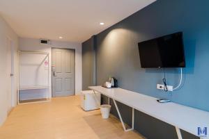 a room with a desk with a tv on the wall at Manonta Budget Hotel in Hat Yai +32 photos