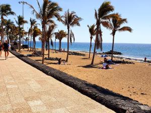 mensen op een strand met palmbomen en de oceaan bij Isabel3 in Tías