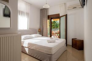 1 dormitorio con 1 cama blanca grande y balcón en Villa Maria 2, en Toroni