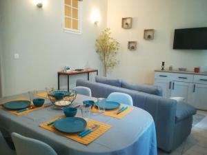 una mesa de comedor con un mantel azul. en Gîte de la Cathédrale - Lectoure, en Lectoure