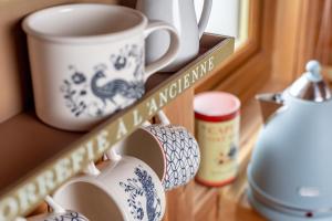 a shelf with a cup and a mug on it at Redlands Country Lodge Apartments with Hot Tubs in Ladybank