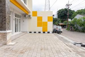 a building with a colorful wall on the side of it at RedDoorz Syariah @ Kebraon in Kebraon
