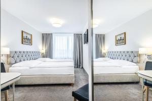 a hotel room with two beds and a mirror at Hotel Podlasie in Białystok