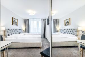 ビャウィストクにあるホテル ポドラシェのベッド2台と鏡が備わるホテルルームです。