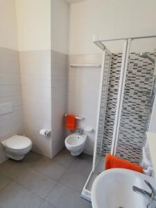 a bathroom with a toilet and a sink and a shower at Appartamenti via Calnova in Noventa di Piave