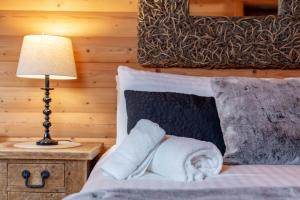 a hotel room with a bed with towels on it at Redlands Country Lodge Apartments with Hot Tubs in Ladybank