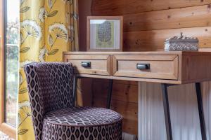 a desk with a chair and a picture on a wall at Redlands Country Lodge Apartments with Hot Tubs in Ladybank