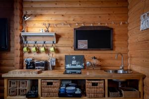 a kitchen with a counter with a sink and a tv at Redlands Country Lodge Apartments with Hot Tubs in Ladybank