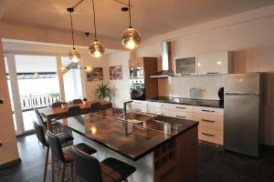 a kitchen with a kitchen island with a stainless steel refrigerator at Lagadin Lakeview Apartment in Ohrid