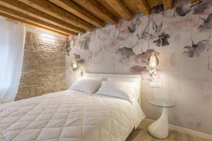 een slaapkamer met een bed en een bakstenen muur bij Hermes San Marco in Venetië