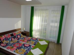 a bedroom with a bed with a colorful comforter at Katamaran in Siófok
