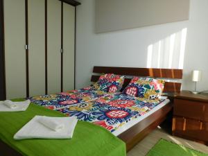 - une chambre avec un lit et une couette colorée dans l'établissement Katamaran, à Siófok