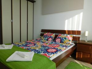 1 dormitorio con 1 cama con un edredón colorido en Katamaran, en Siófok