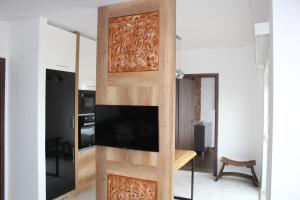 焦爾的住宿－Quelle-Apartman 2，客厅设有木门和电视