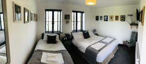 two beds in a small room with windows at The Players Golf Club in Bristol