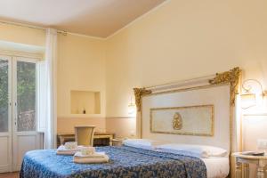 een slaapkamer met 2 bedden en handdoeken bij Relais Tiffany in Florence