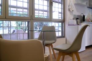 zwei Stühle und ein Tisch in einem Raum mit Fenstern in der Unterkunft Moncloa room apartments in Madrid + 11 Fotos