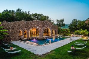 a stone house with a swimming pool in a yard at La Cerreta - Terme di Sassetta in Sassetta