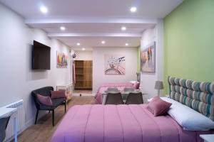 a bedroom with two beds and a table and chairs at Moncloa room apartments in Madrid