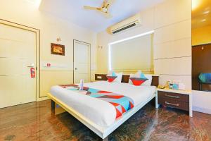 a bedroom with a large bed and a desk at FabExpress B Zone in Chennai