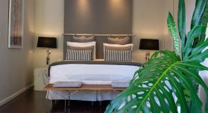 a bedroom with a bed and a table with a plant at Casa Geranio in Rio de Janeiro