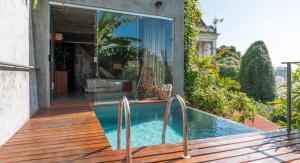 une maison avec une piscine et une terrasse en bois dans l'établissement Casa Geranio, à Rio de Janeiro