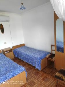 Habitación con 2 camas y espejo. en Guest House Chanba, en Gudauta