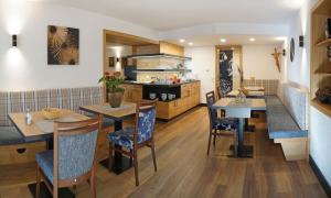 a dining room with tables and chairs and a kitchen at Haus Carola in Bad Füssing