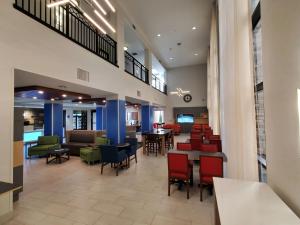 グレンデールにあるHoliday Inn Express & Suites Phoenix Glendale Dist, an IHG Hotelのテーブルと椅子が備わる病院のロビー