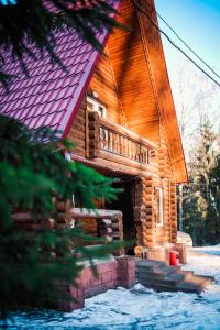 Cabaña de madera con techo rojo en Krasnoye Ozero Resort, en Korobitsyno