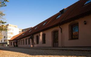 a building with a brown roof on a street at Hotel Green Gondola in Plzeň