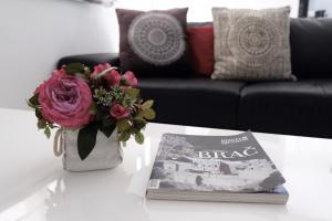 a vase of flowers and a book on a table at Villa Tonika in Povlja