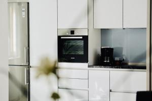 una cocina con armarios blancos y horno negro en Villa Tonika, en Povlja