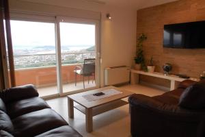 uma sala de estar com um sofá e uma grande janela em Apartment Jukic em Klis