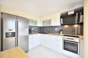 uma cozinha com armários brancos e electrodomésticos de aço inoxidável em Apartment Jukic em Klis