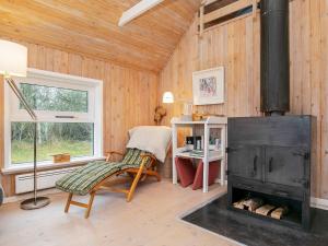 Kandestederneにある7 person holiday home in Skagenの暖炉、椅子、窓が備わる客室です。