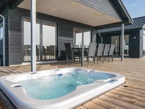 a hot tub on a deck with a table and chairs at 12 person holiday home in Haderslev in Haderslev