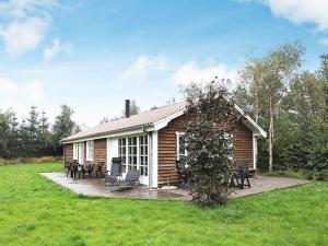 a log cabin with tables and chairs in front of it at Holiday Home Lyngstien in Torup Strand