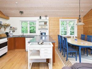 eine Küche mit einem Tisch und blauen Stühlen in der Unterkunft Holiday Home Lyngstien in Torup Strand