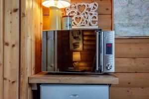 a microwave sitting on top of a wooden wall at Redlands Country Lodge Apartments with Hot Tubs in Ladybank