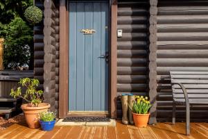 a blue front door of a house with potted plants at Redlands Country Lodge Apartments with Hot Tubs in Ladybank