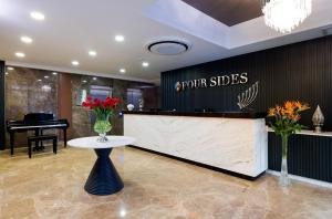 a front desk of a store with a vase of flowers at Four Sides Sisli in Istanbul