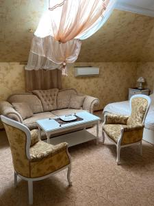 a living room with a couch and a table and chairs at Hotel Lux Angliter in Vologda