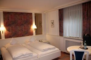 a hotel room with a white bed and a window at Gästehaus Sonja in Durach