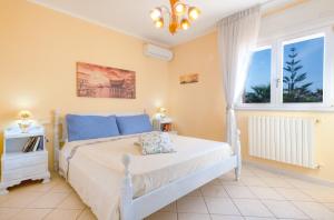 a bedroom with a white bed and a window at Villa Christelle Luxury Pescoluse by HDSalento in Marina di Pescoluse
