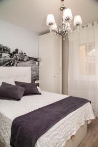 a bedroom with a large bed and a chandelier at Catamarán in Castro-Urdiales